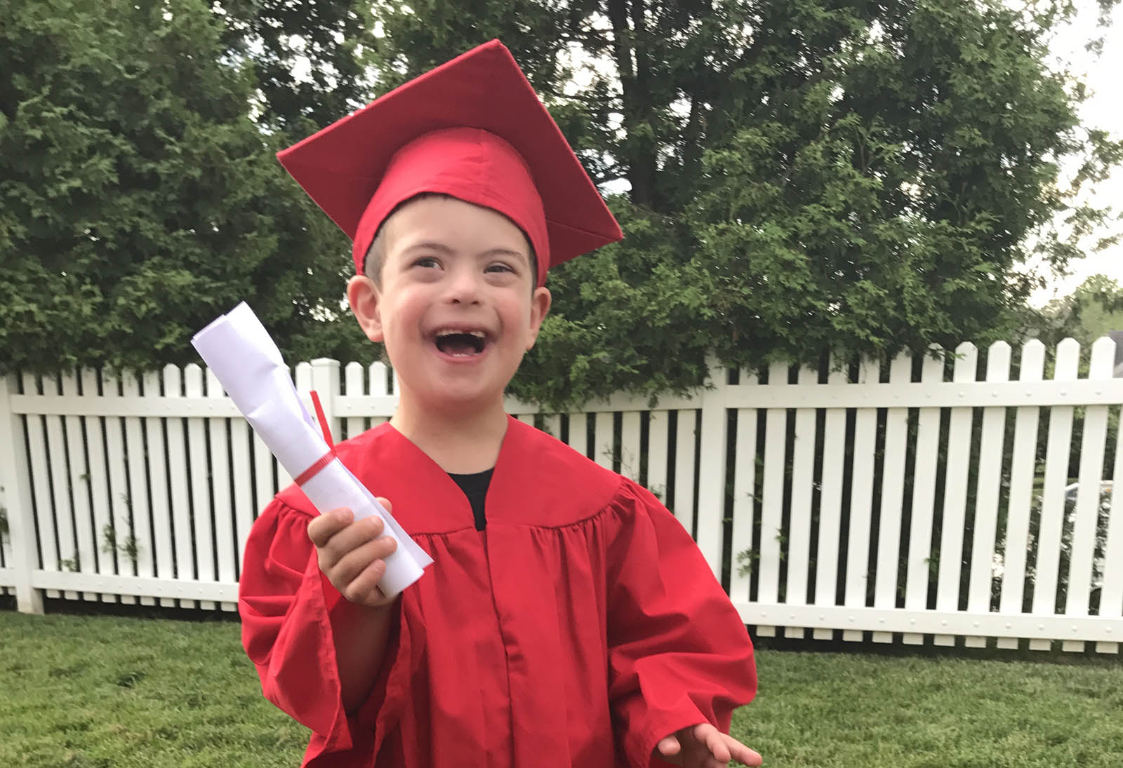 Child celebrating in a graduation gown