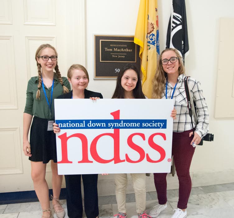 Group of people hold NDSS sign