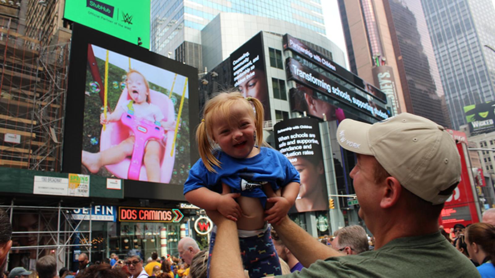 Man lifts young girl into air.