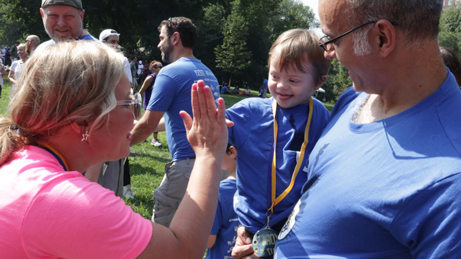 Woman high-fives a young child.