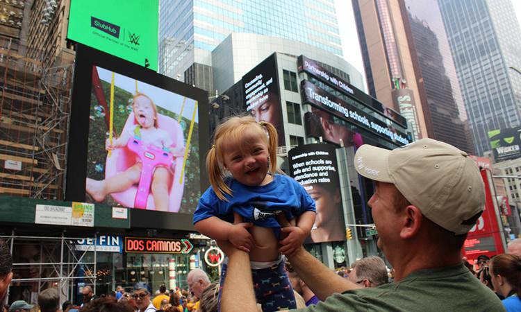 Man lifts young girl into air.