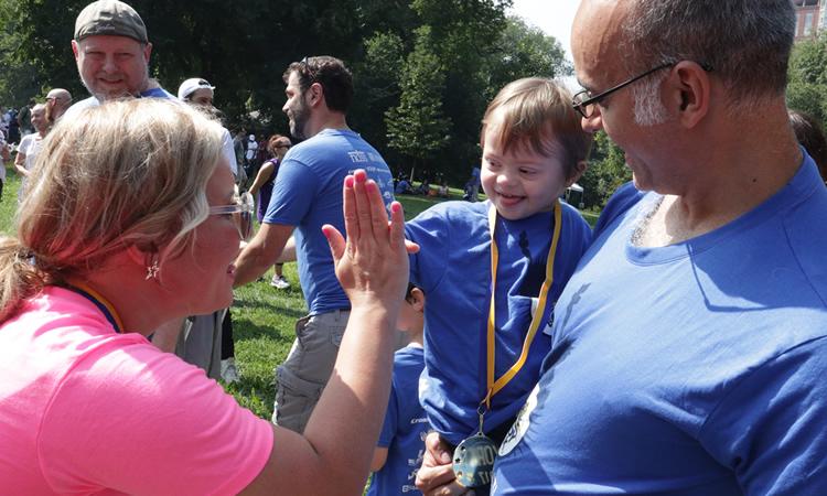 Woman high-fives a young child.