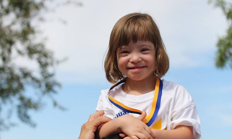 A young child smiles.