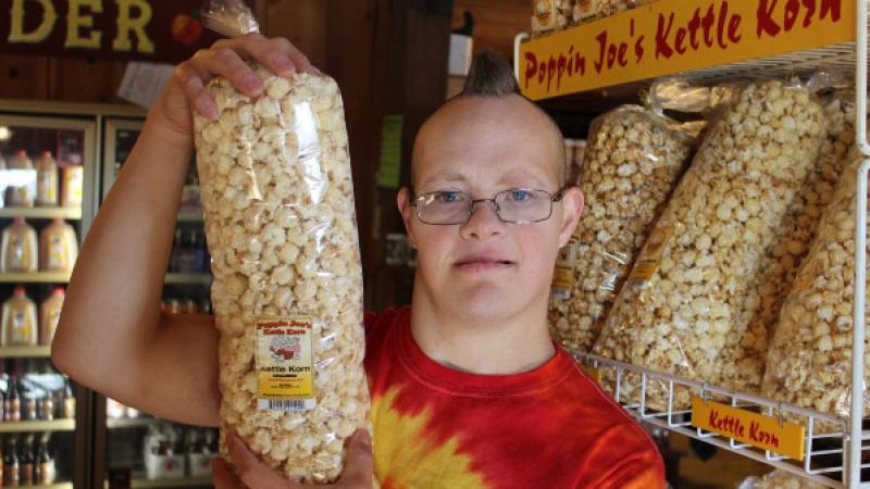 Boy holds large, plastic bag of popcorn