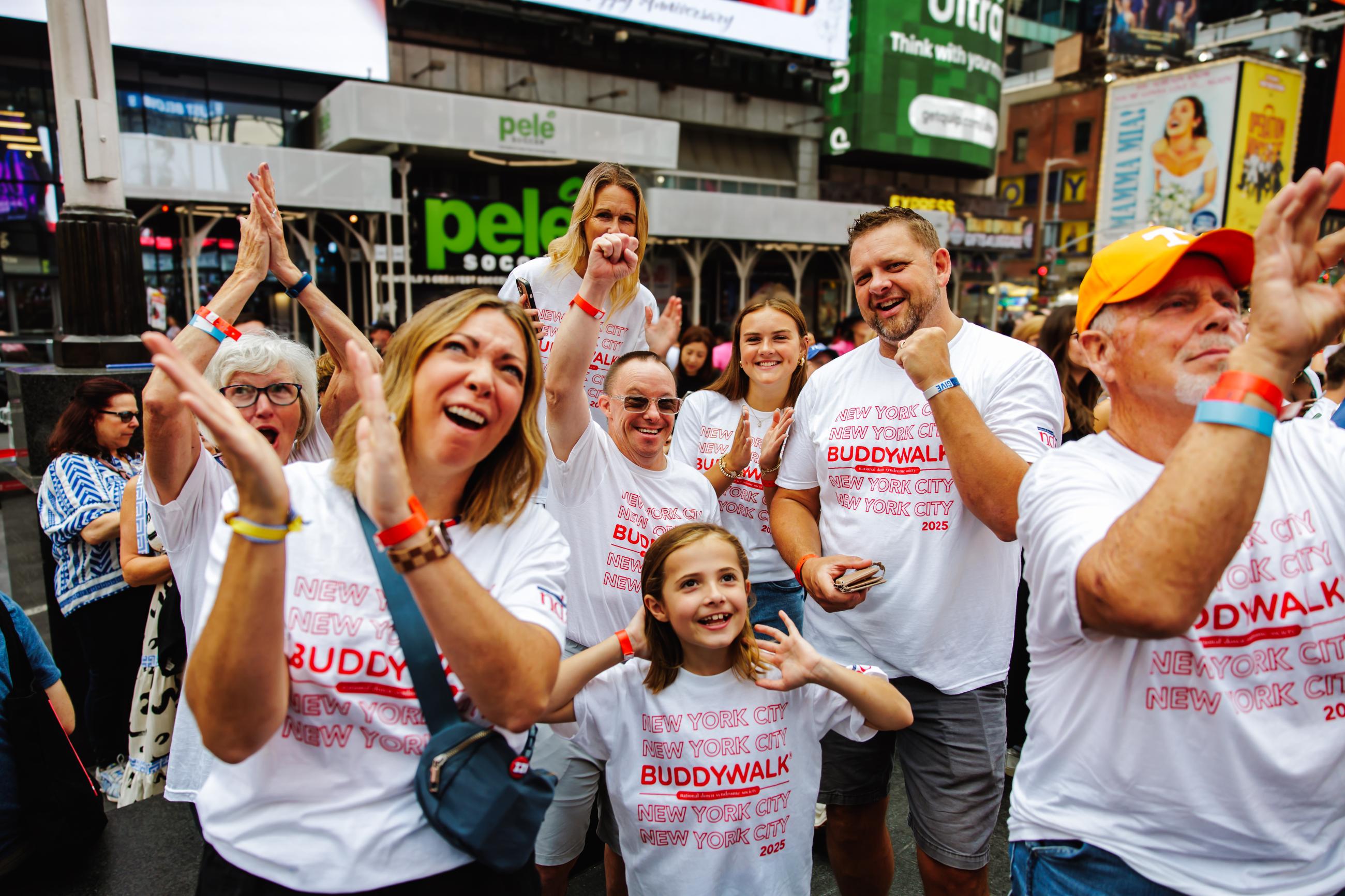 A family wearing Buddy Walk t-shirts celebrates at Times Square