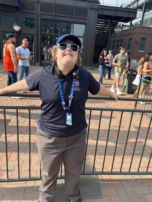 adult woman with Down syndrome wearing her Chicago cubs polo, smiling at work