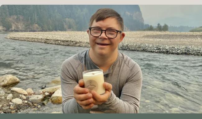 man with down syndrome holds candle for his business