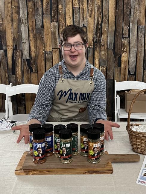 max crawford, a man with down syndrome, poses in front of the spice mixes he makes