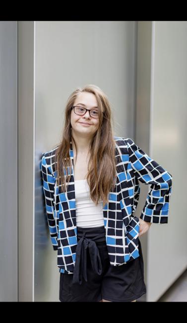 woman with down syndrome poses with a blazer for her headshot
