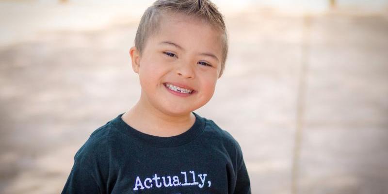 young boy with down syndrome smiling
